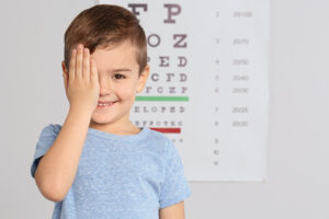 Cute little boy visiting children's doctor, space for text. Eye examination