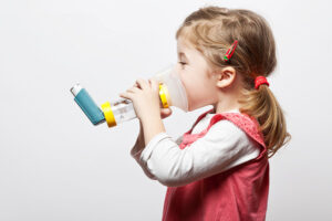 little girl doing inhlation using her inhaler