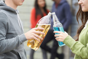 Close Up Of Teenage Group Drinking Alcohol Together